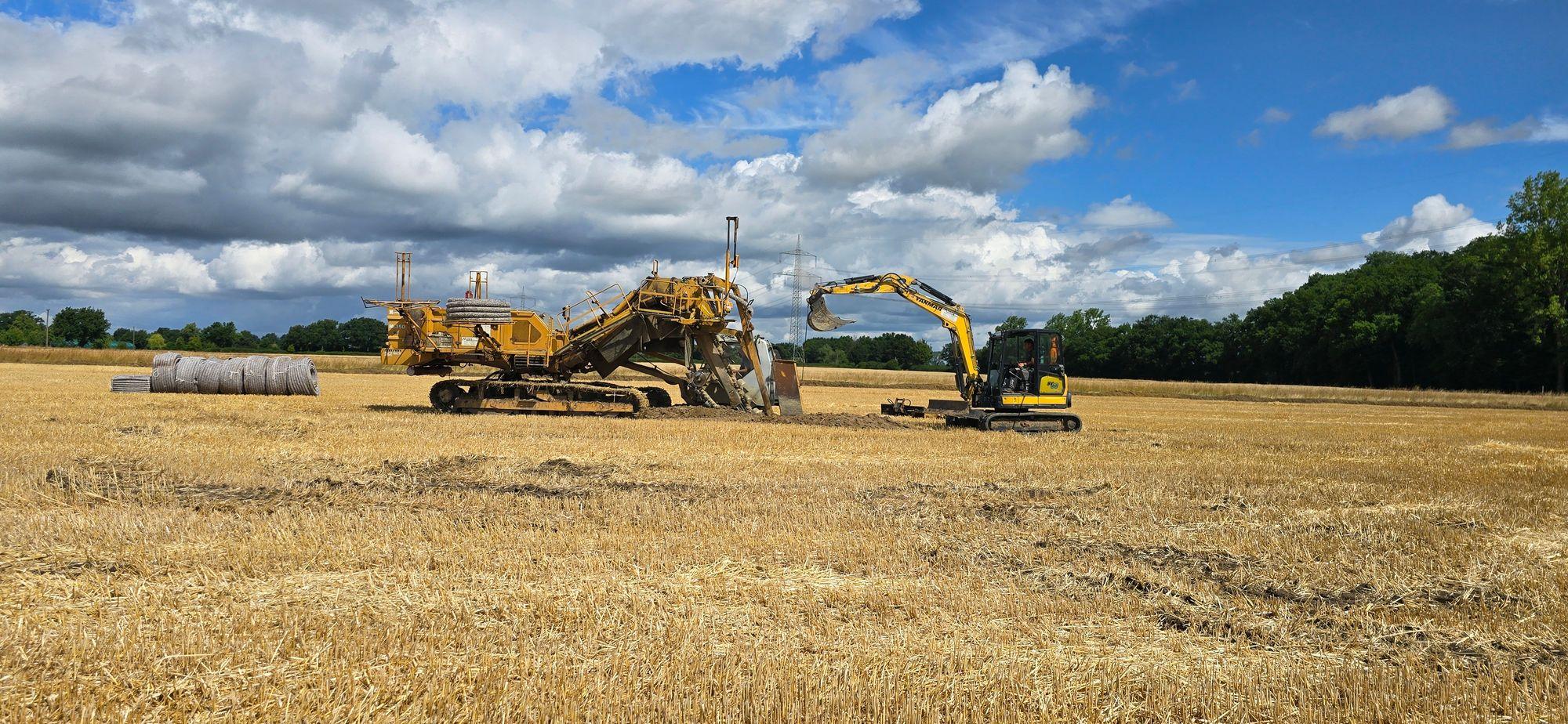 Drainagemaschine im Einsatz - gemeinsam mit kleinem Bagger.