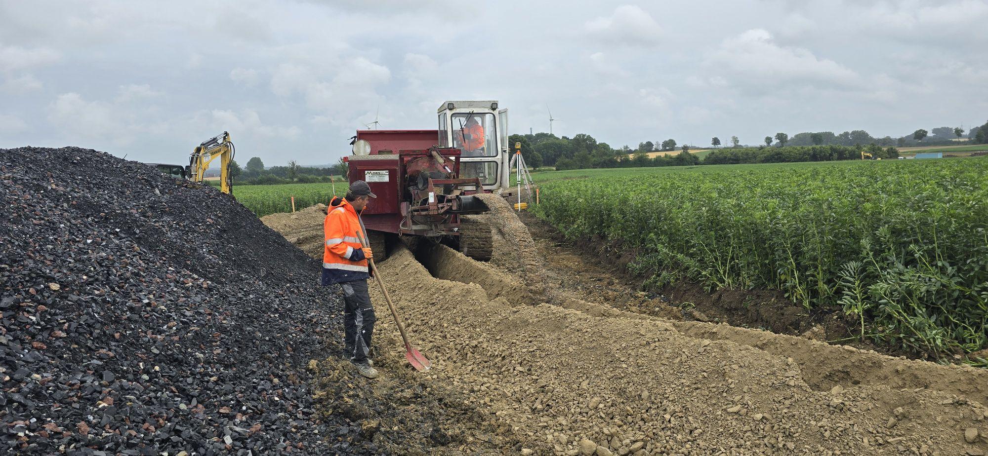 Der Graveltruck füllt Kies in die zuvor gefrästen Draingräben. Kies ist wasserdurchlässig und filterstabil. Dies gewährleistet eine dauerhafte und unmittelbare Versickerung des Oberflächenwassers.