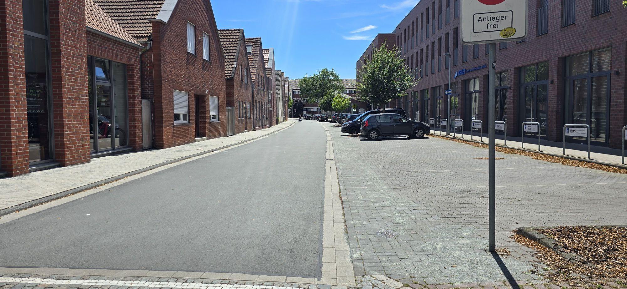 Ein Blick vom anderen Ende der Straße: Die sanierte Neustraße in Aspaltbauweise mit Anarbeitung der vorhandenen Parkflächen.